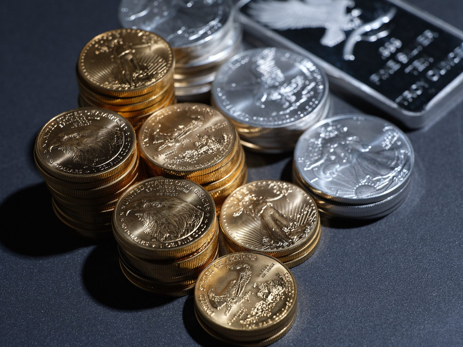 Gold and silver bullion coins and a silver bar, photographed at Alex Lexington in Chamblee, Georgia
