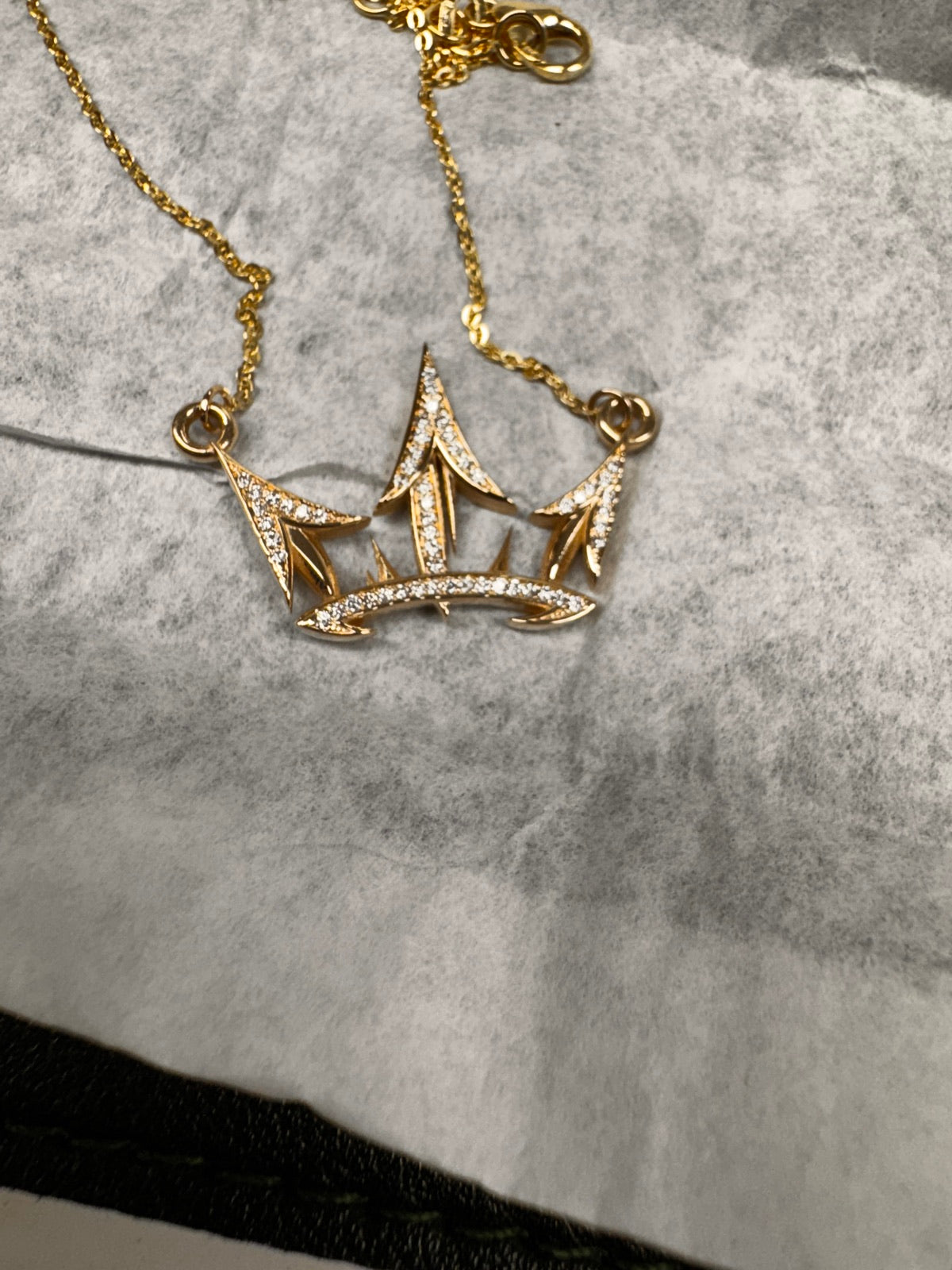 A gold crown pendant set with diamonds